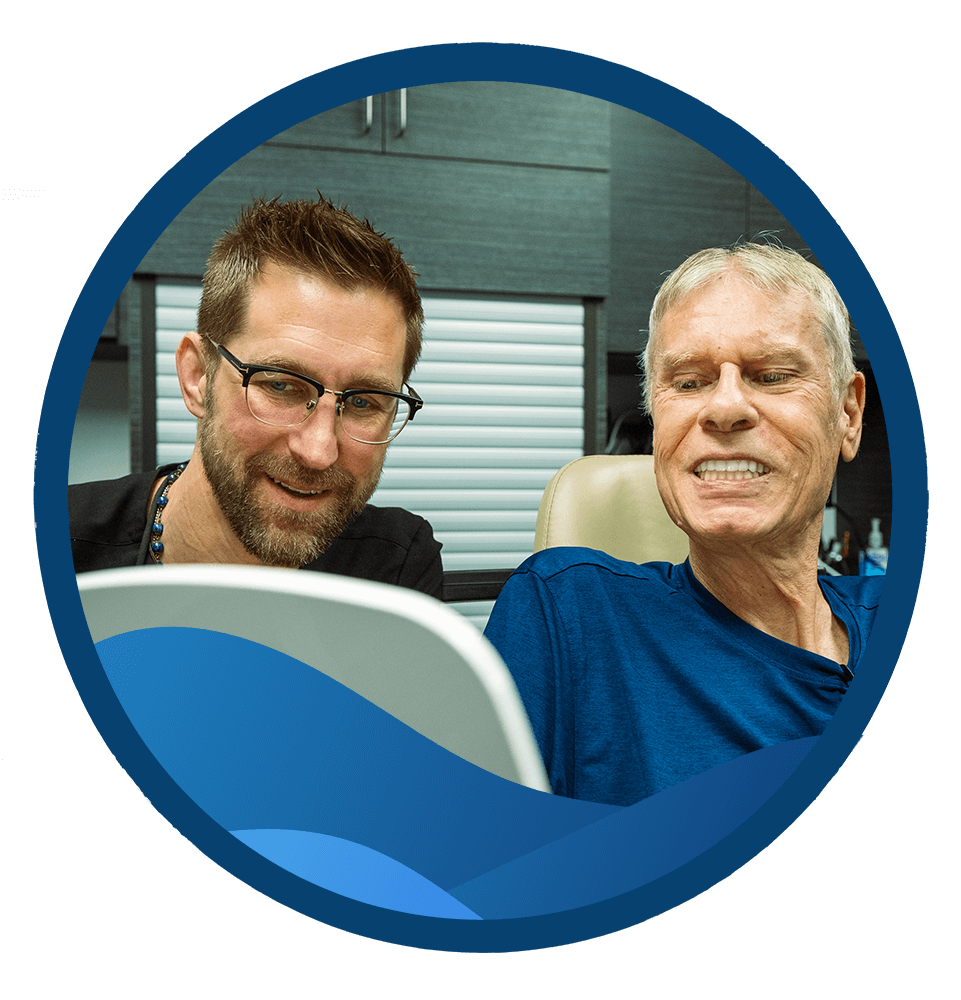 patient looking into mirror to see results of dental procedure