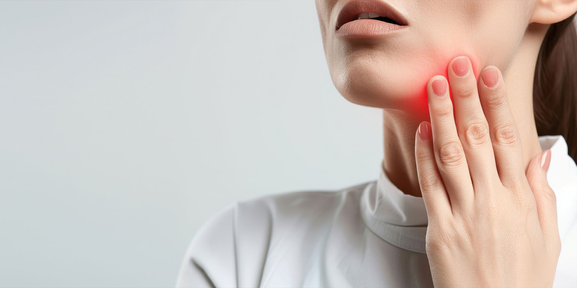 woman experiencing jaw pain, illustrating discomfort and health issues related to dental problems or temporomandibular joint disorders