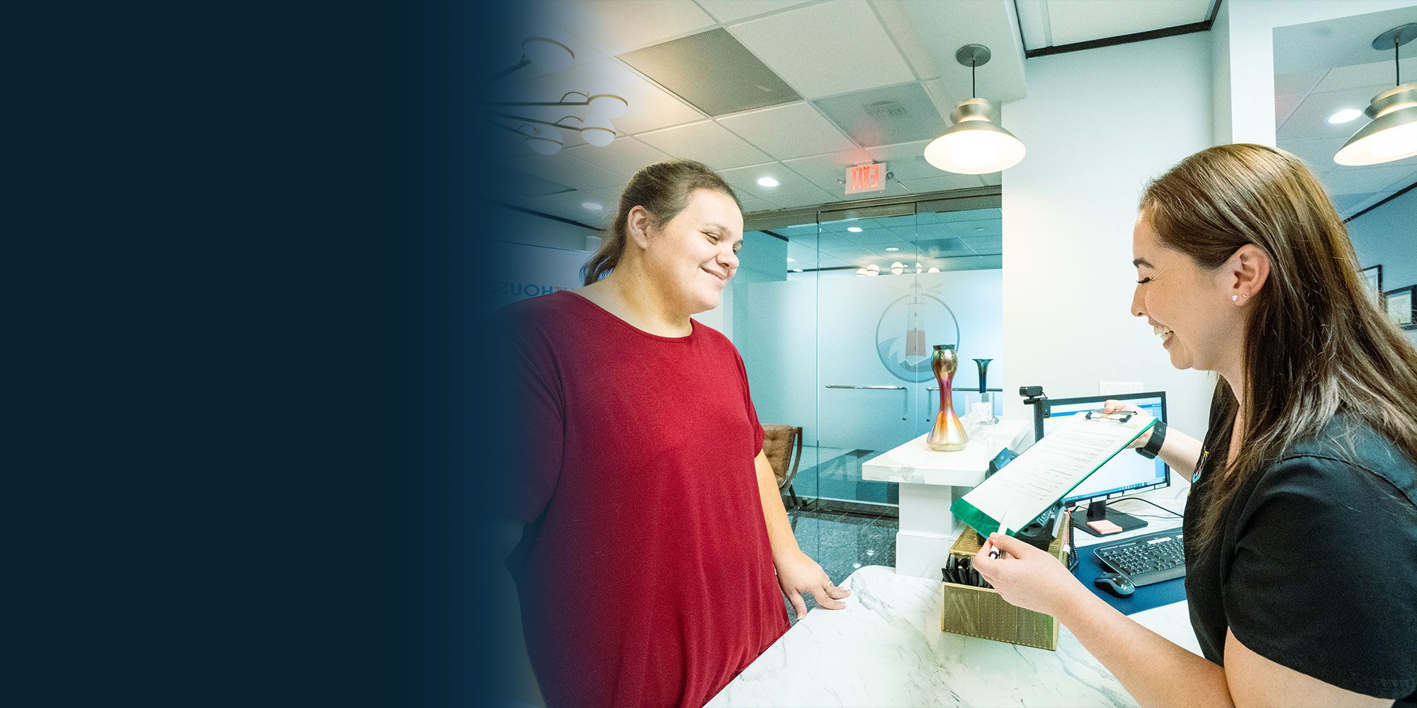 Staff member helping patient at the front desk of the dental practice
